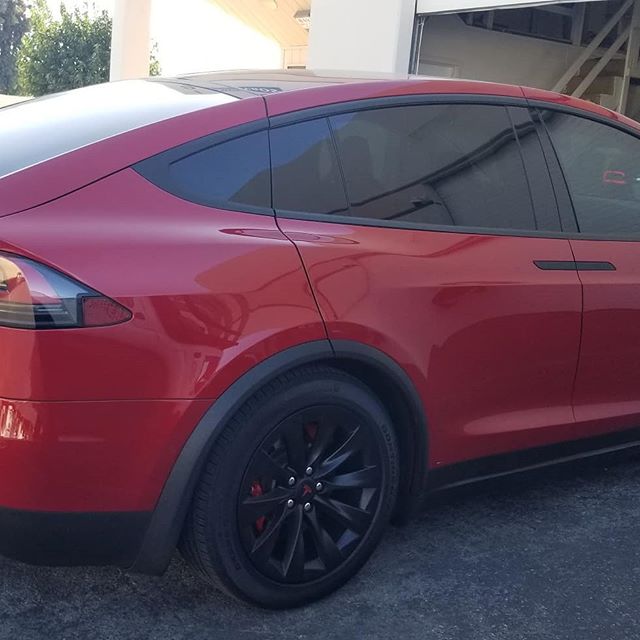 red tesla with tinted windows