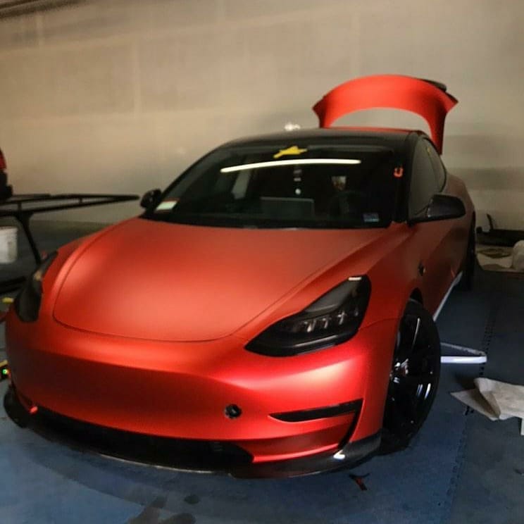 Wrapped red tesla with tinted windows